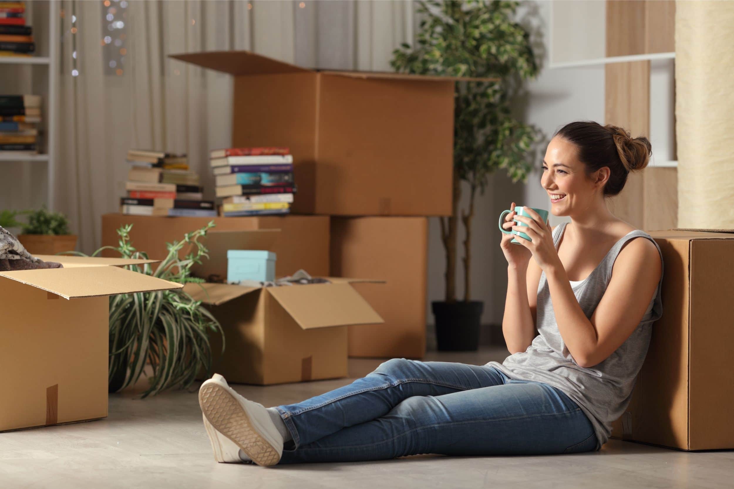 Happy tenant resting and drinking coffee while moving home