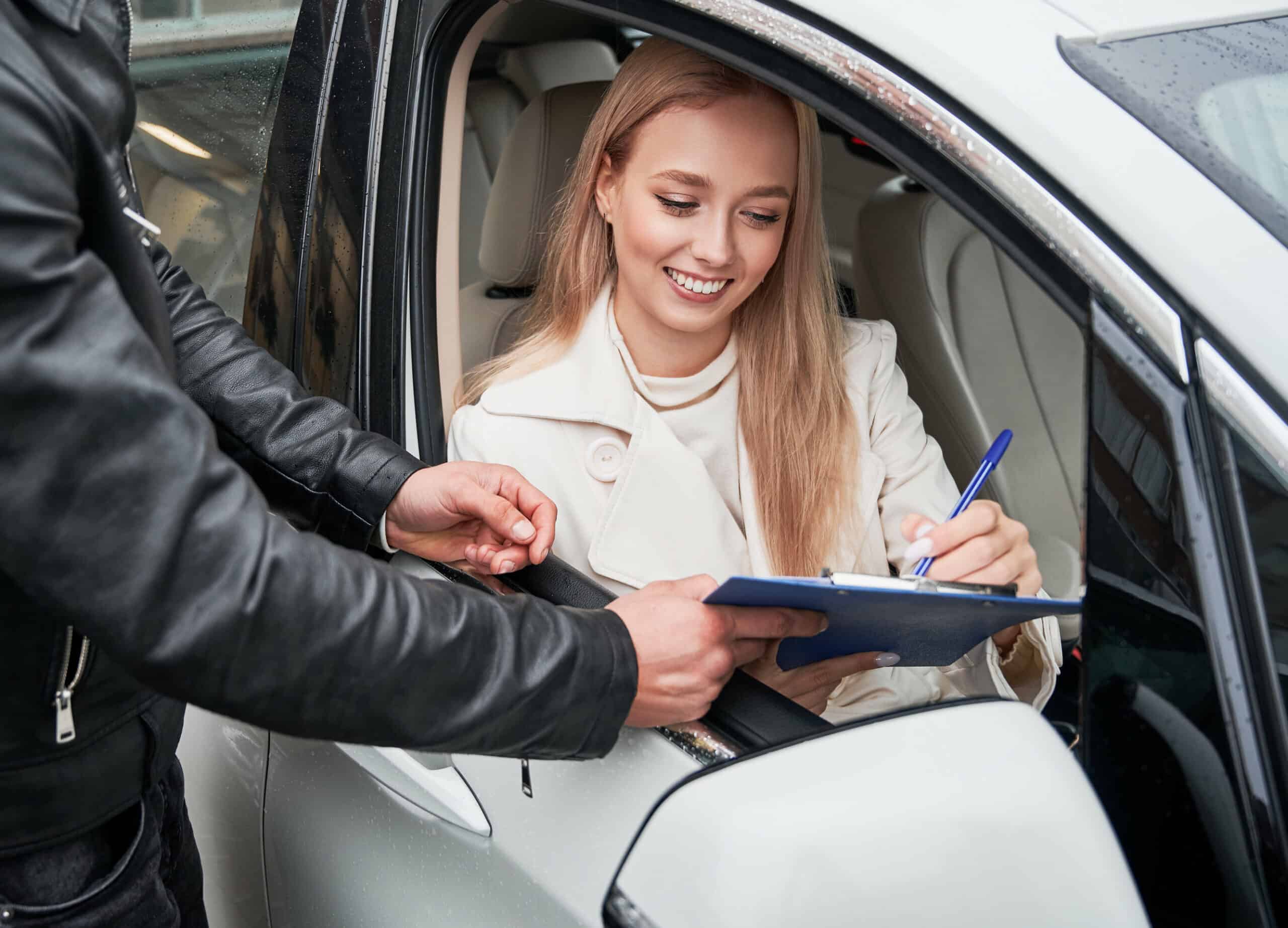 Man and woman at car dealership buying new car