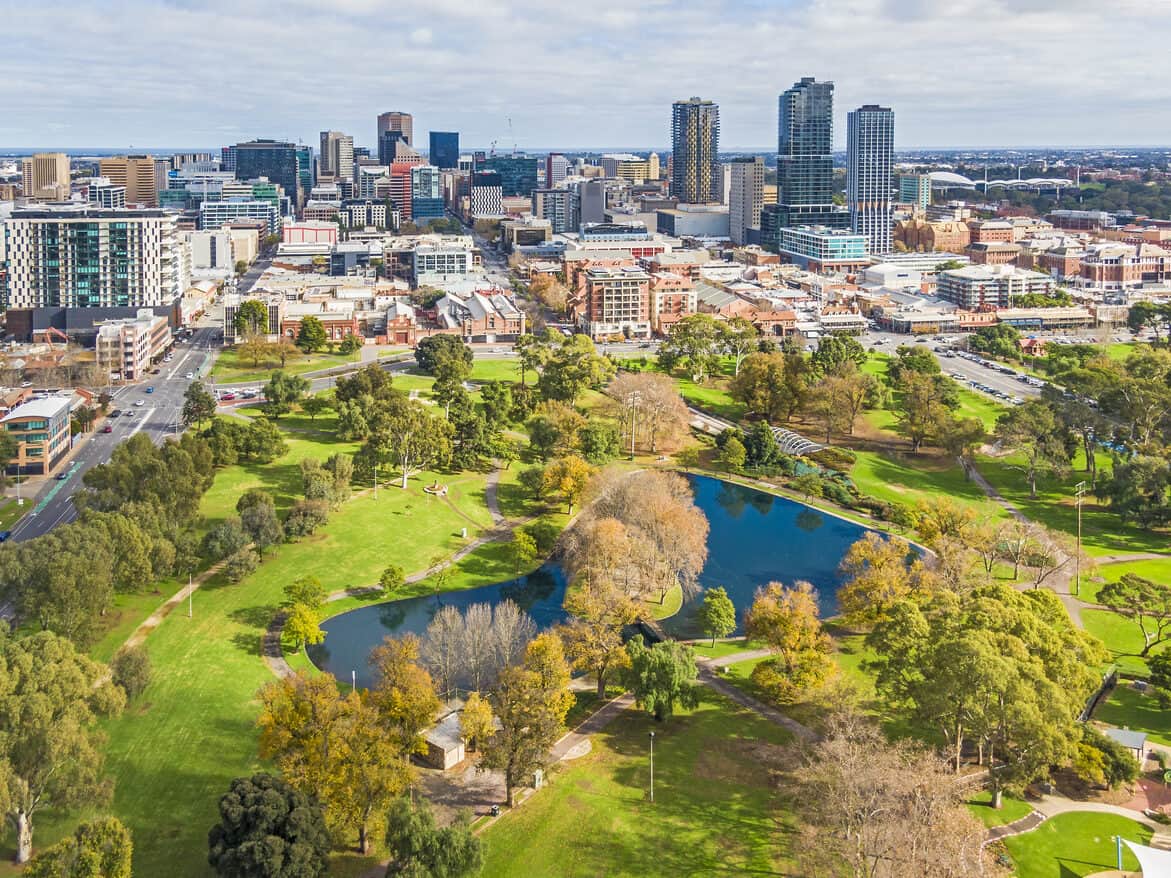 aerial-view-small-capital-city-buildings-with-vibrant-green-park-and-blue-lake