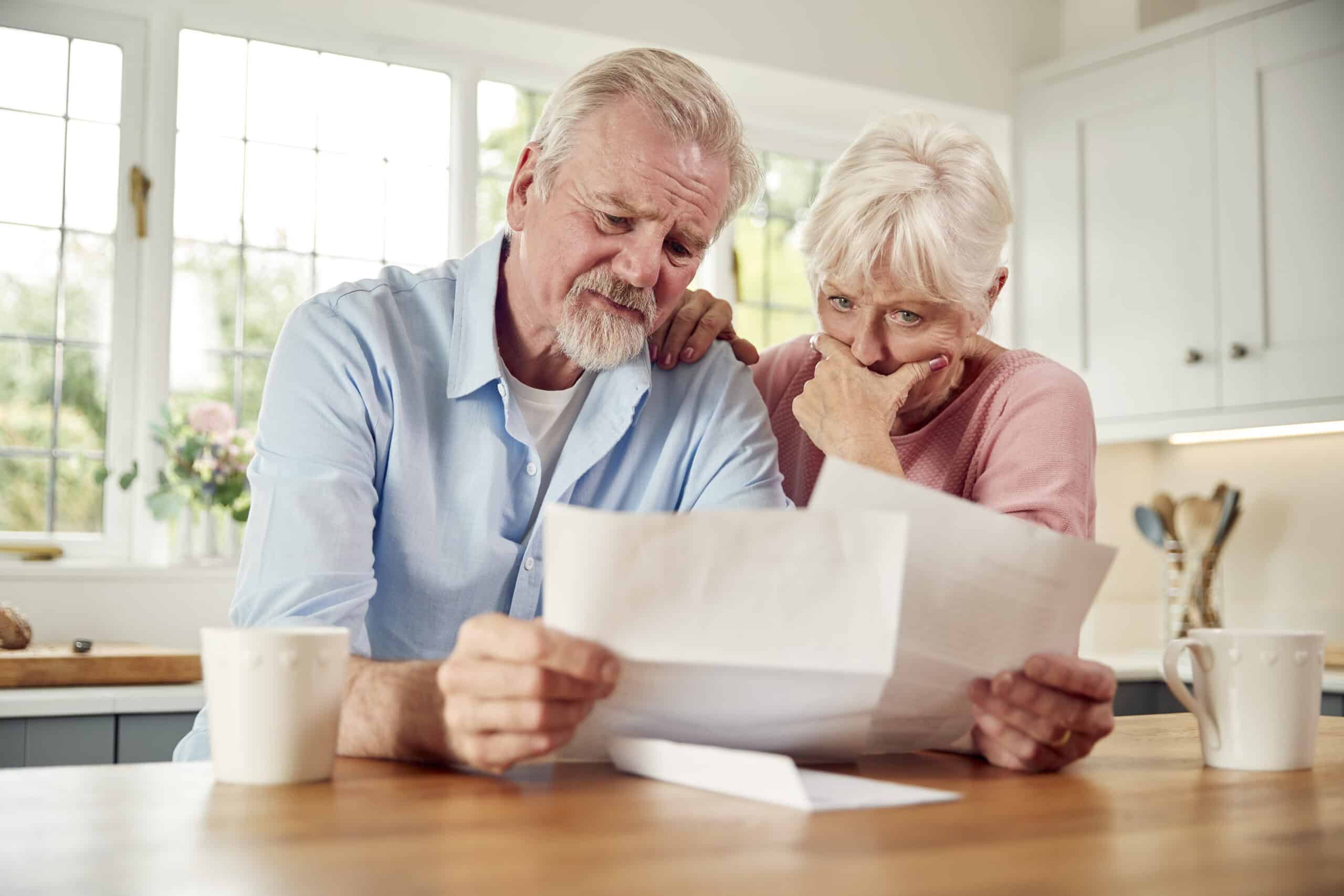 Worried Retired Senior Couple Looking At Bills At Home Concerned About Cost Of Living