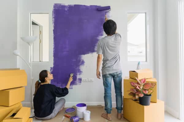 two people painting a wall